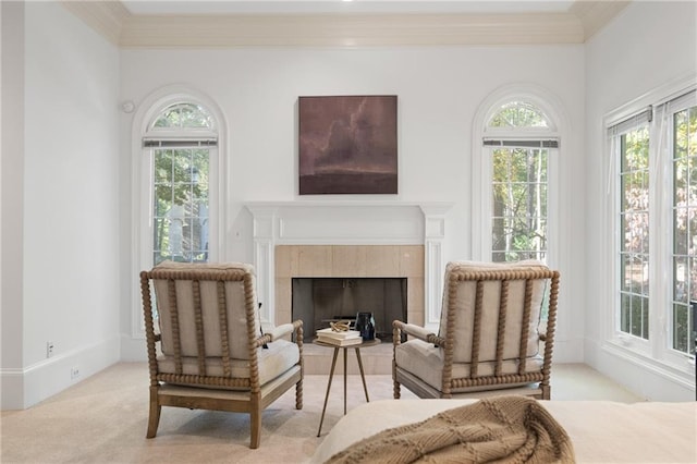 living area featuring a tiled fireplace, light carpet, and crown molding