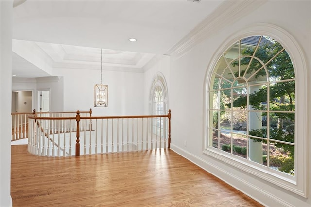 hallway featuring ornamental molding, light wood-type flooring, and a chandelier