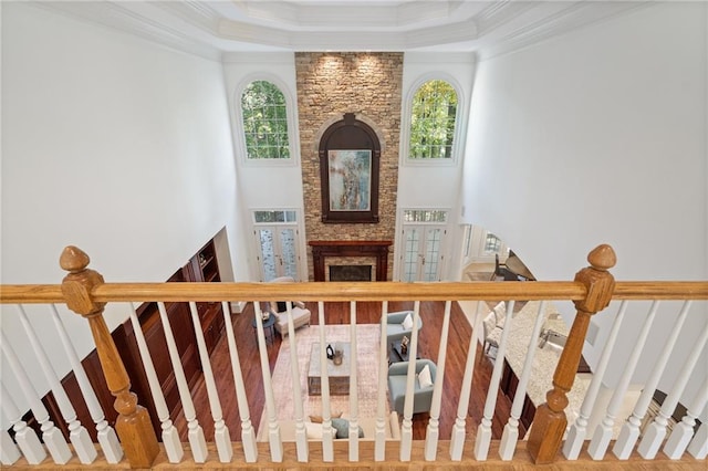 staircase featuring a healthy amount of sunlight, a large fireplace, and ornamental molding