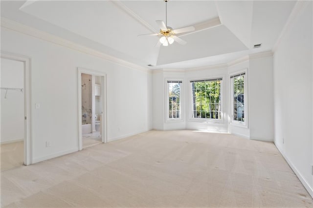 interior space with crown molding, light carpet, ceiling fan, and a tray ceiling