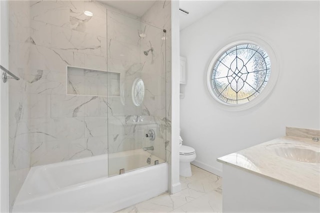 full bathroom featuring vanity, tiled shower / bath combo, and toilet