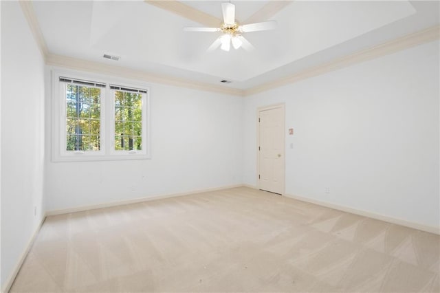 unfurnished room featuring light carpet, ceiling fan, and a tray ceiling