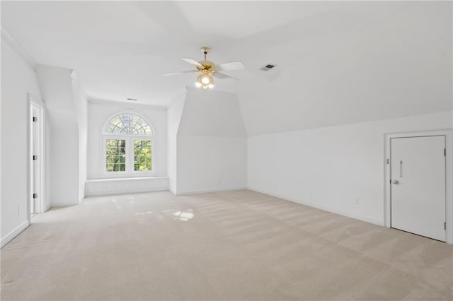 additional living space featuring light carpet, ceiling fan, and vaulted ceiling