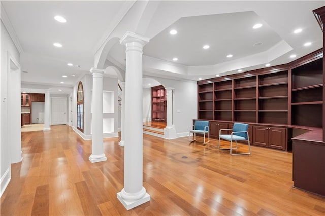 interior space with ornamental molding, light hardwood / wood-style flooring, and decorative columns