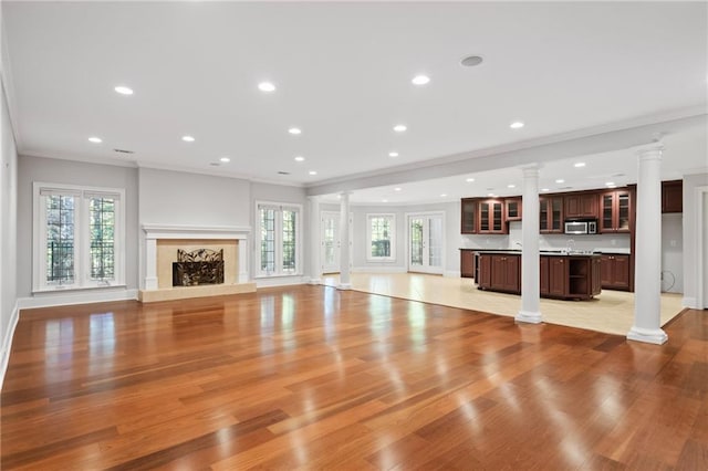 unfurnished living room with light hardwood / wood-style floors and crown molding