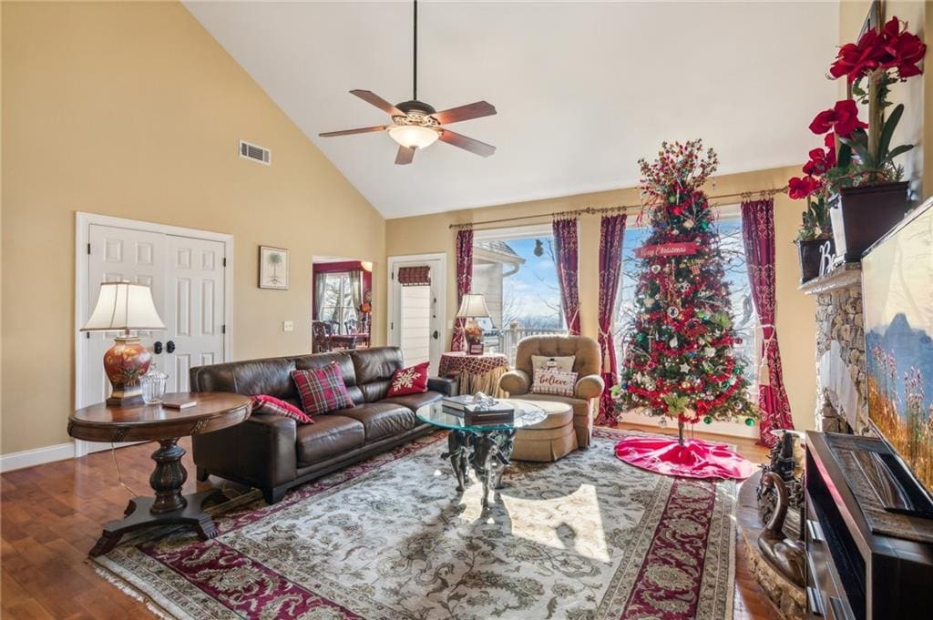 living room with wood-type flooring, high vaulted ceiling, and ceiling fan