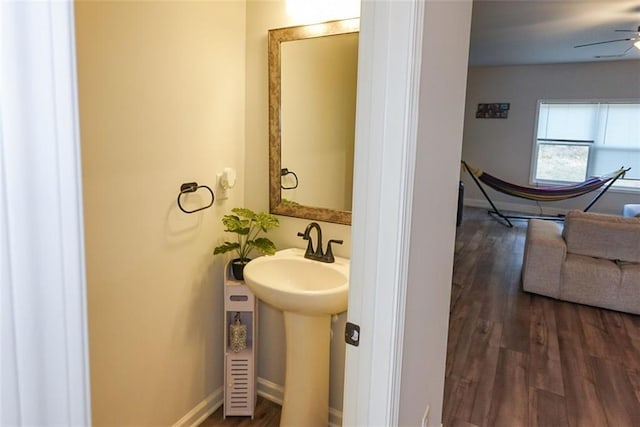 bathroom with a ceiling fan, a sink, baseboards, and wood finished floors