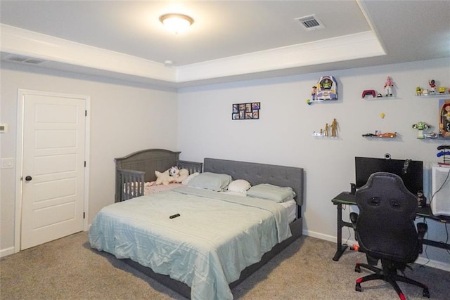 bedroom featuring a tray ceiling, carpet flooring, and visible vents