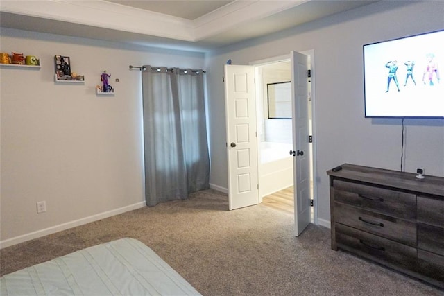 carpeted bedroom featuring a tray ceiling and baseboards