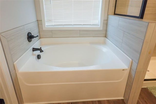 bathroom featuring a stall shower and a bath