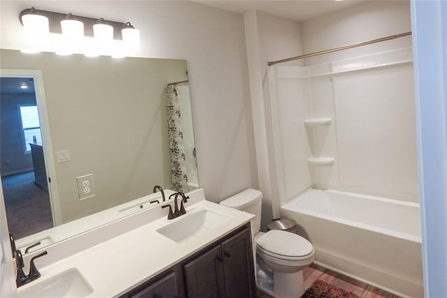 full bath with a sink, toilet, and double vanity