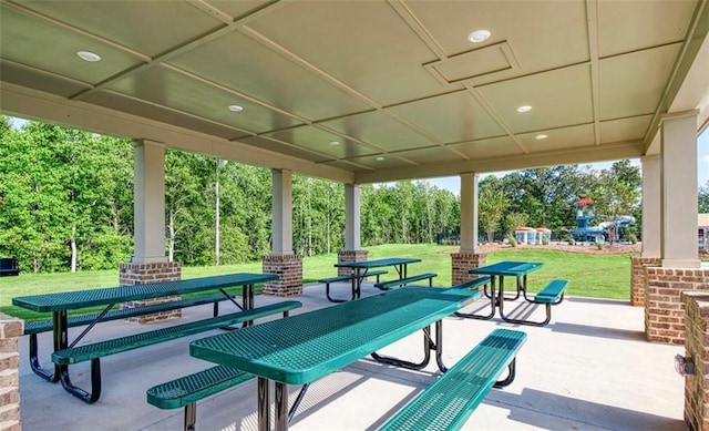 view of property's community featuring a lawn and a patio