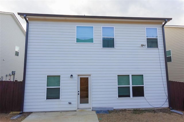 back of property featuring a patio area and fence