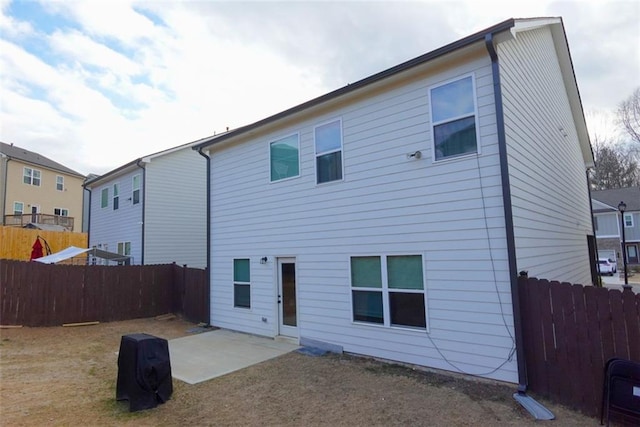 back of property with a patio area and a fenced backyard