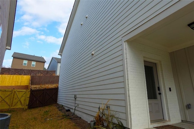 view of side of home with central AC unit and fence