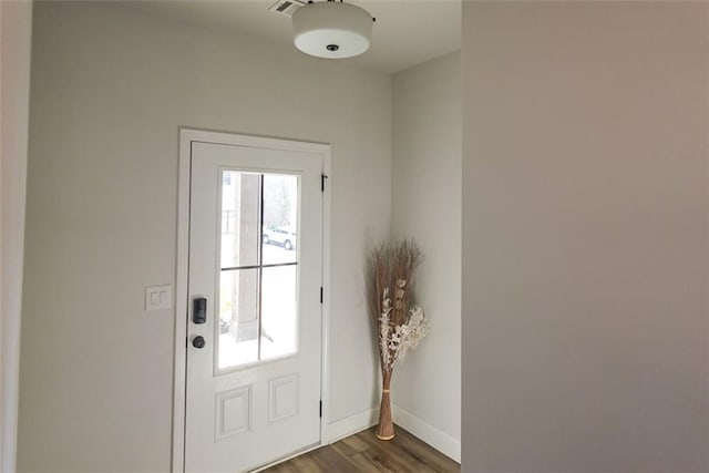 doorway with dark wood finished floors and baseboards