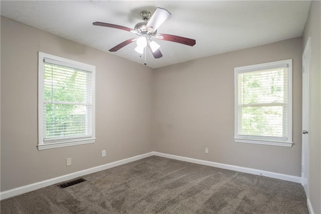 unfurnished room featuring baseboards, visible vents, a healthy amount of sunlight, and carpet floors