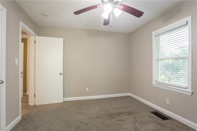 unfurnished room with visible vents, ceiling fan, baseboards, and carpet floors