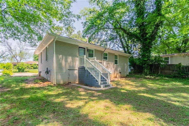 back of property with fence and a yard