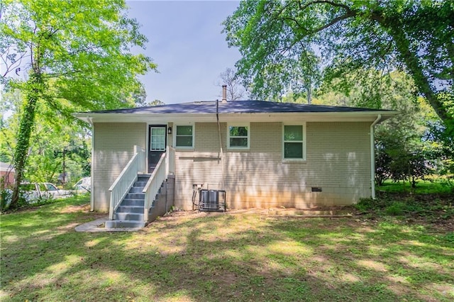 back of house with a lawn, brick siding, central AC, and crawl space