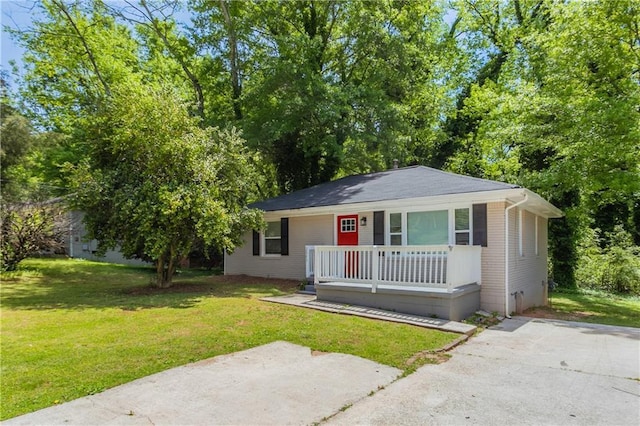 view of front of home featuring covered porch, brick siding, and a front lawn