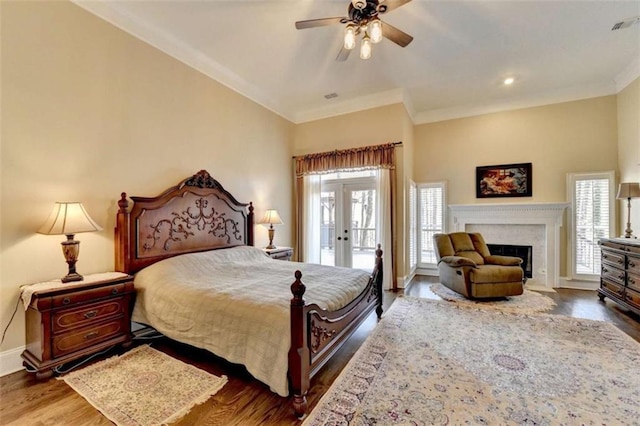 bedroom with baseboards, a fireplace with flush hearth, ornamental molding, dark wood-type flooring, and access to outside