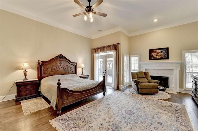 bedroom featuring a fireplace, dark wood finished floors, ceiling fan, access to outside, and baseboards