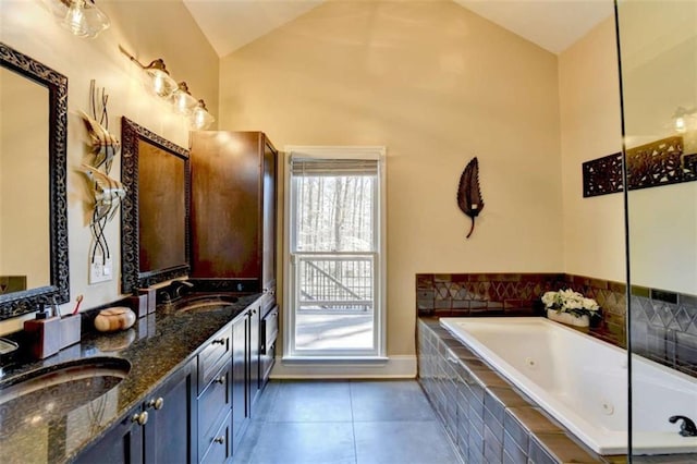 bathroom featuring double vanity, a tub with jets, a sink, and tile patterned floors