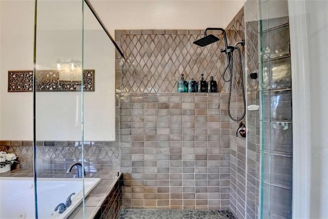 bathroom featuring a whirlpool tub and a tile shower