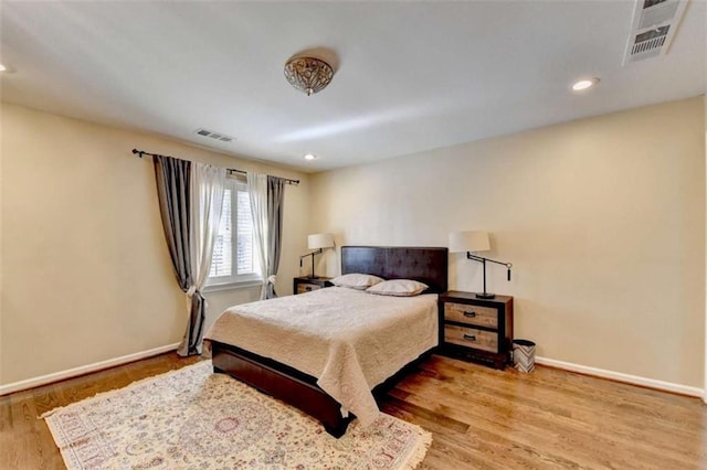 bedroom with recessed lighting, visible vents, baseboards, and wood finished floors