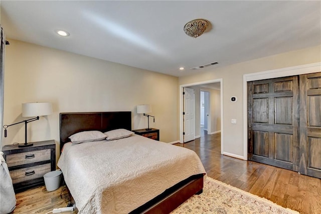 bedroom with dark wood-style floors, recessed lighting, visible vents, and baseboards