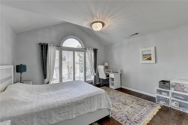 bedroom with dark wood-style floors, visible vents, vaulted ceiling, and baseboards