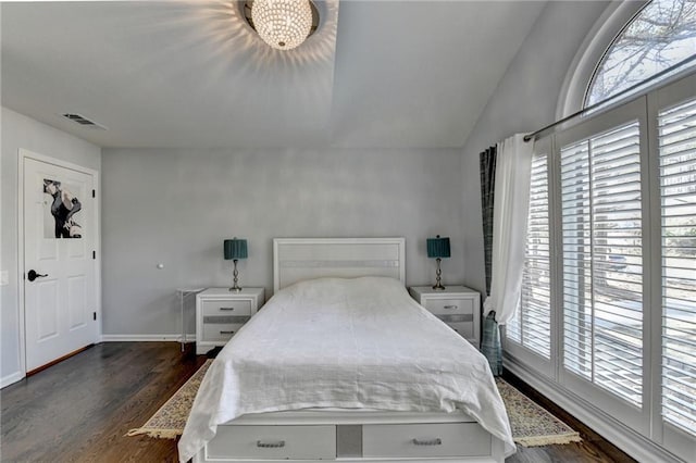 bedroom with lofted ceiling, baseboards, visible vents, and dark wood-type flooring