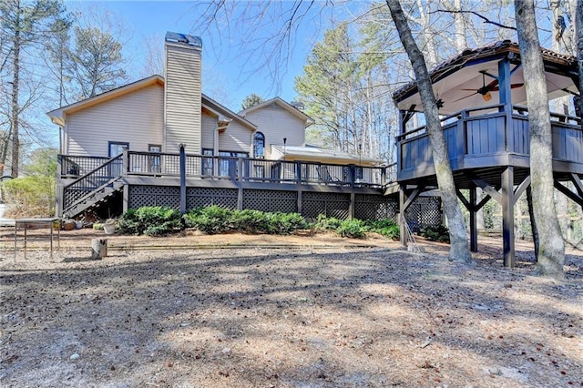 rear view of house with stairway, a chimney, a deck, and a ceiling fan