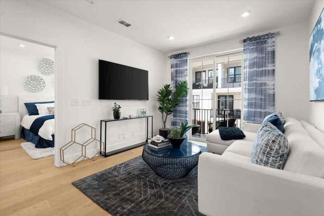 living area with wood finished floors, recessed lighting, and visible vents