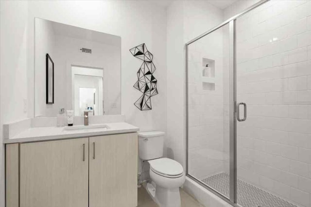bathroom featuring a stall shower, toilet, and vanity