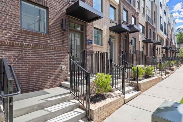 entrance to property with brick siding and a residential view