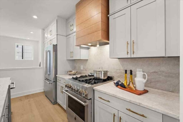 kitchen featuring custom exhaust hood, light hardwood / wood-style flooring, white cabinets, and high quality appliances