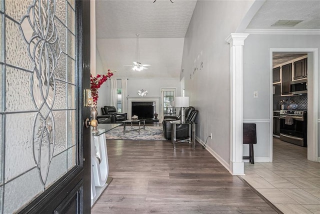 609 Ashton Manor Dr, Loganville, GA 30052 - entryway featuring decorative columns, ceiling fan, a textured ceiling, a fireplace, and baseboards