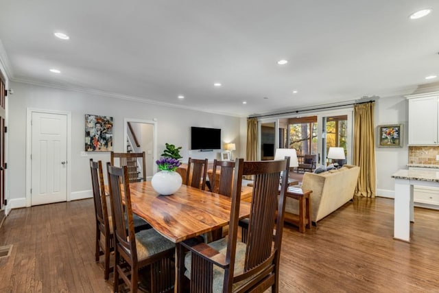 dining room with crown molding and dark wood-type flooring