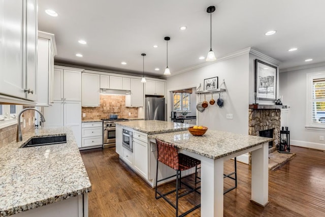 kitchen featuring pendant lighting, sink, white cabinetry, and a kitchen island