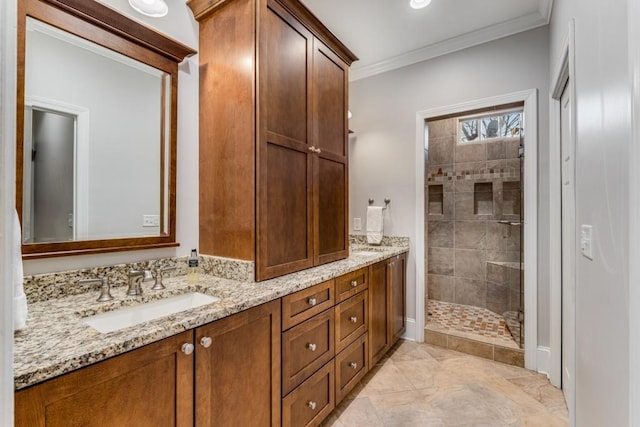 bathroom featuring a tile shower, vanity, and ornamental molding