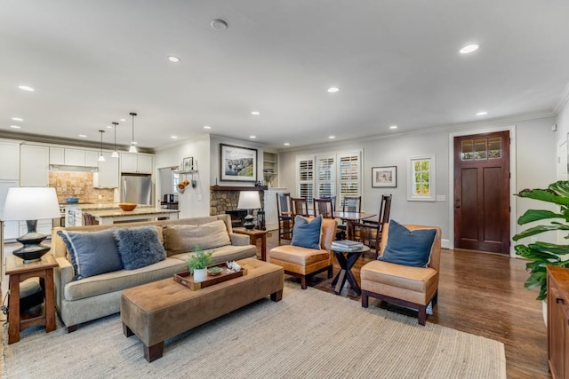 living room featuring ornamental molding, a fireplace, and light hardwood / wood-style flooring