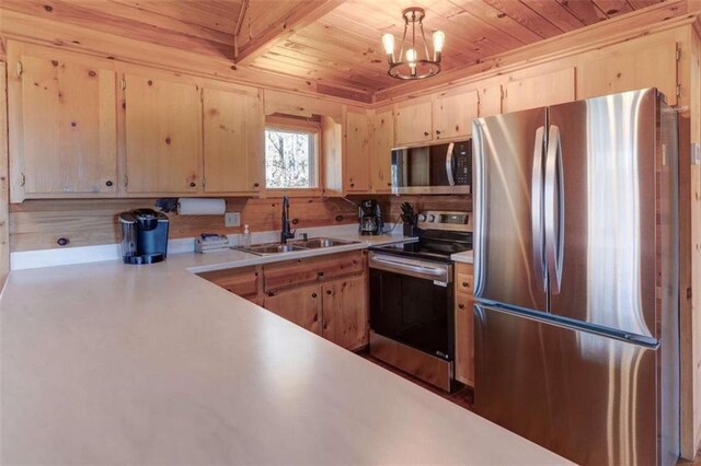 kitchen with light countertops, hanging light fixtures, appliances with stainless steel finishes, light brown cabinets, and a sink