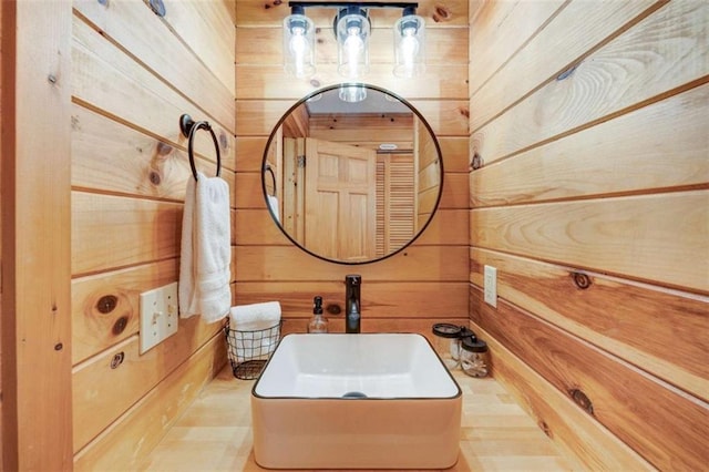 bathroom featuring wooden walls and vanity