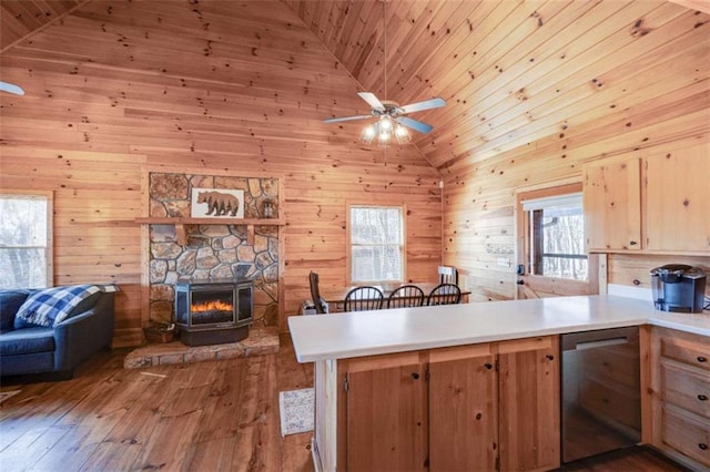 kitchen featuring lofted ceiling, light wood-style flooring, open floor plan, a peninsula, and light countertops