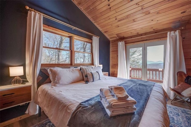 bedroom with wood ceiling, vaulted ceiling, a mountain view, wood finished floors, and access to outside