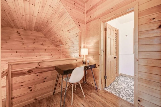 home office featuring wood walls, wood ceiling, vaulted ceiling, and light wood-style floors