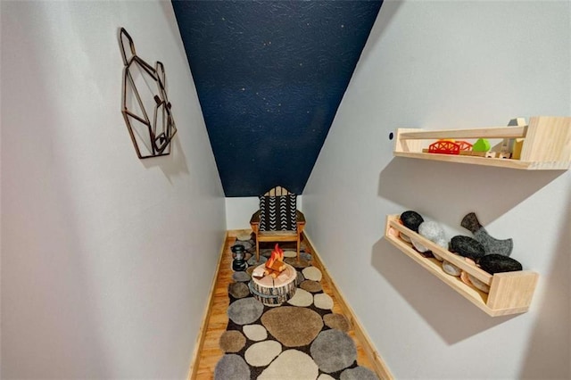 corridor featuring baseboards and wood finished floors