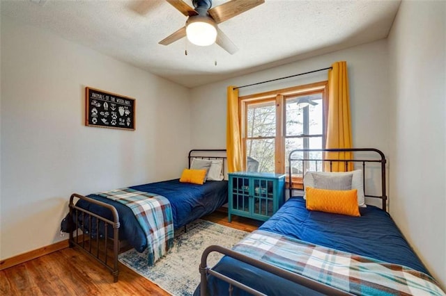 bedroom featuring ceiling fan, wood finished floors, and baseboards